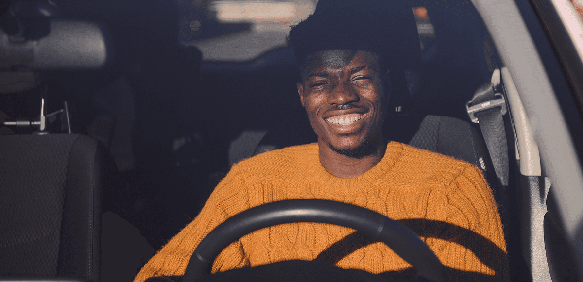 Rideshare driver smiling behind the wheel